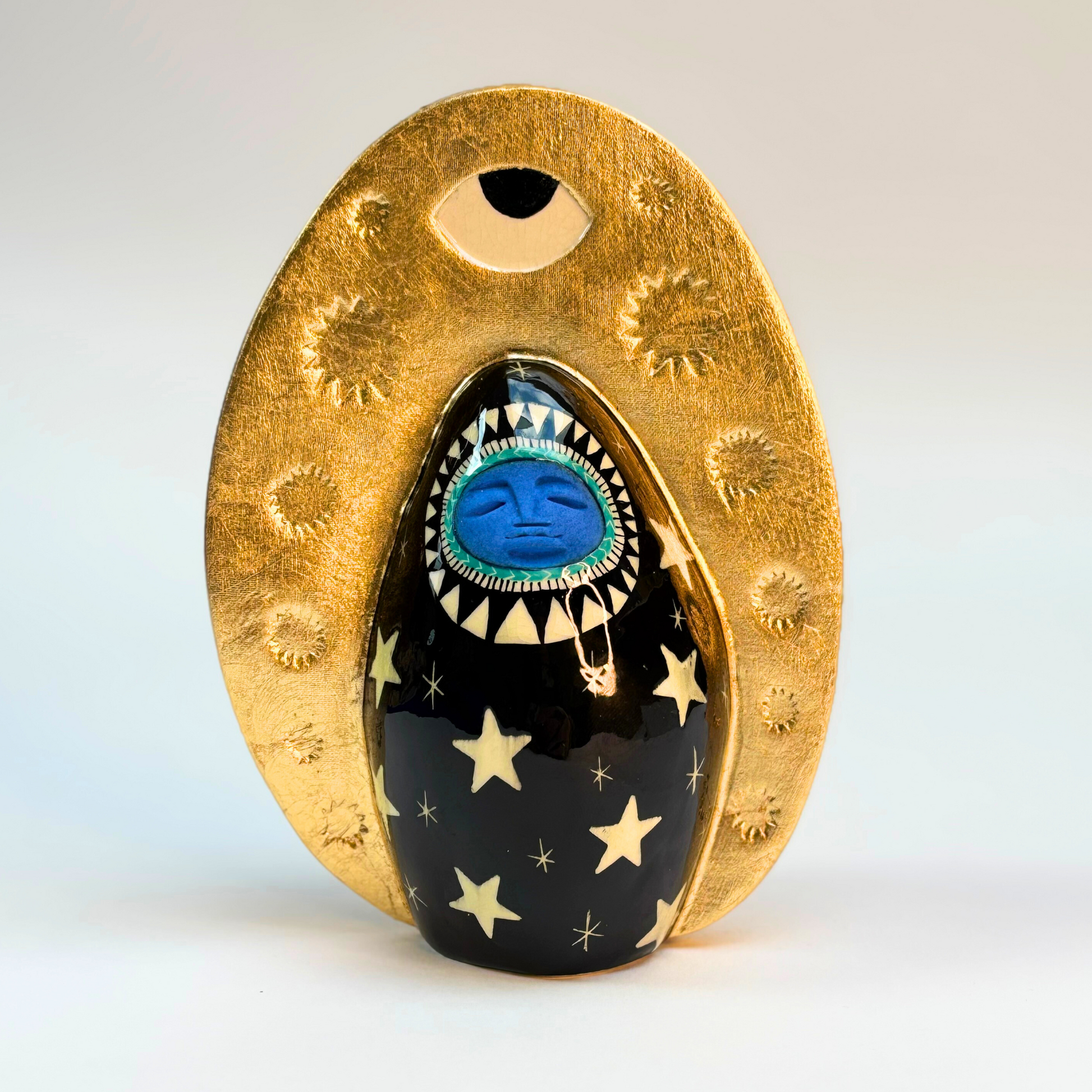 front view of ceramic goddess black ground hand painted black with white stars and gold crown surround