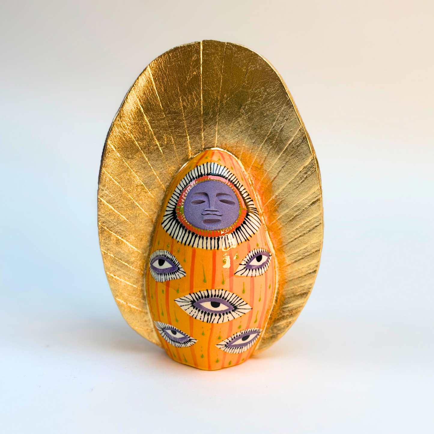 16cm ceramic goddess with lavender colour face and eye design on body with gold crown
